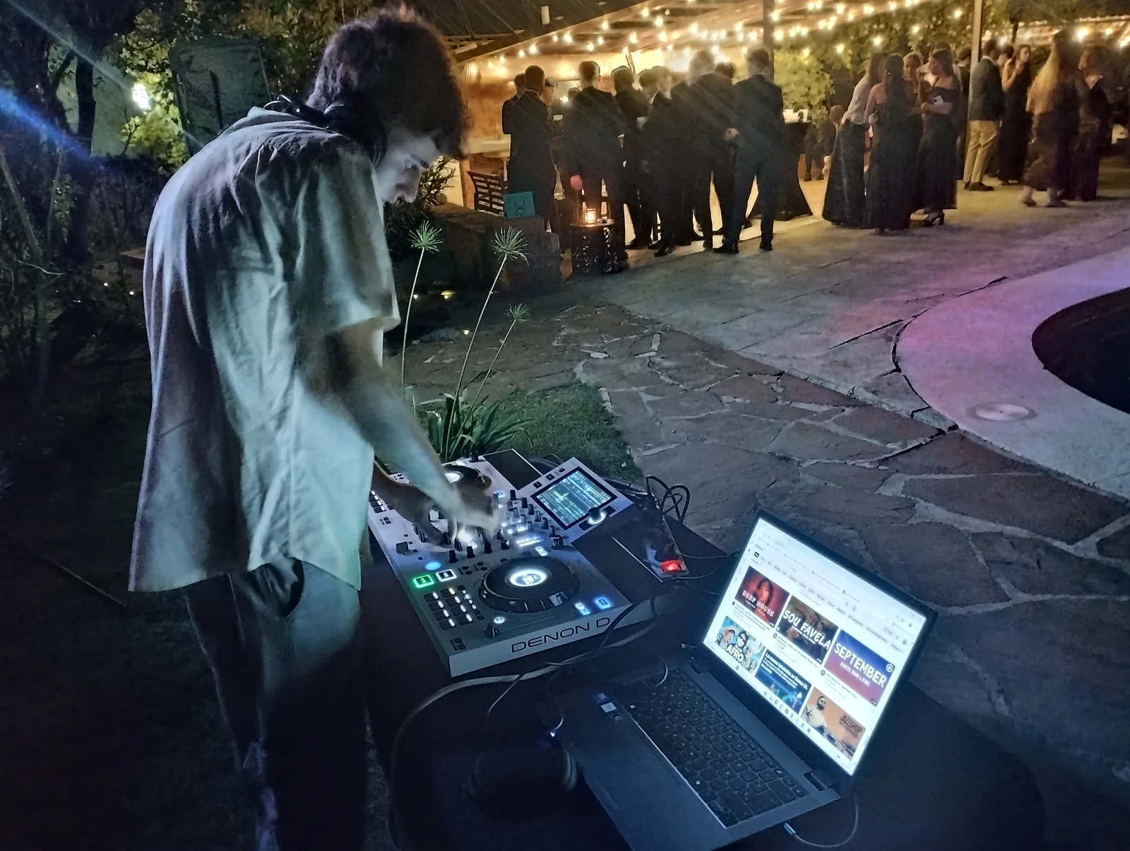 DJ pinchando en boda al aire libre nocturna